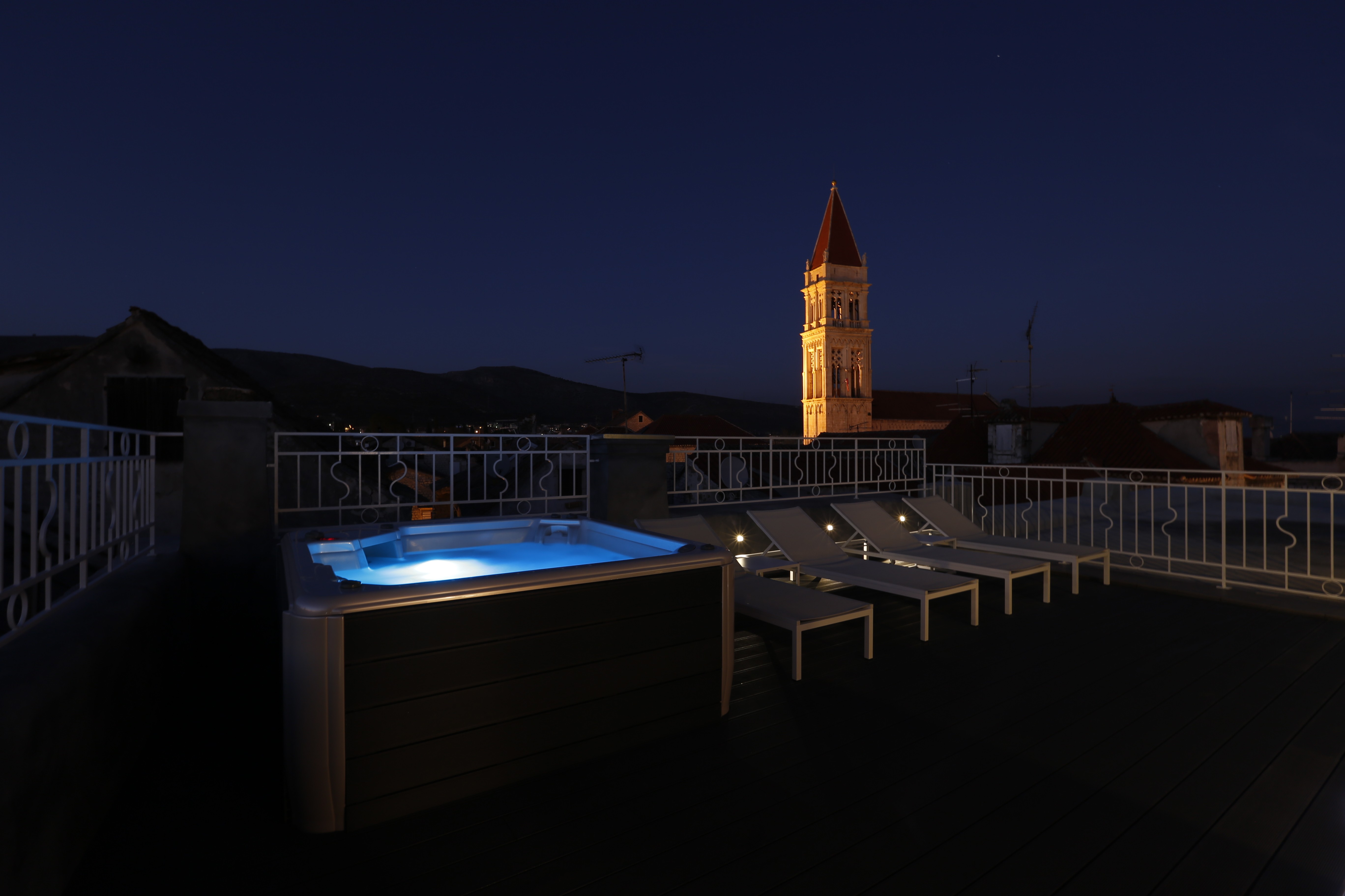 Rooftop terrace with a hot tub at night